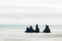 Looking for a new desktop wallpaper from Iceland  Some rocks in the ocean near Vik  - for more of my minimalistic landscape feel free to check my Insta glacionaut