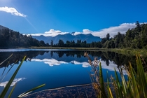Lucky break in the clouds before the water ripples covered the surface Lake Matheson NZ 