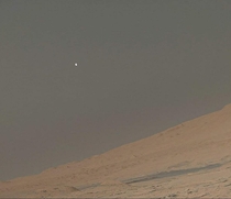Martian Moonrise an afternoon shot of the moon Phobos over the northern limb of Mount Sharp