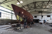 Me in front of an old ship in an abandoned shipyard 