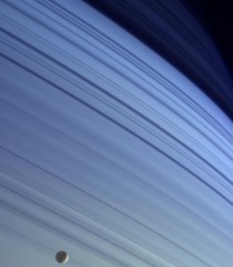 Mimas drifts along in its orbit against the azure backdrop of Saturns northern latitudes in this true color view 