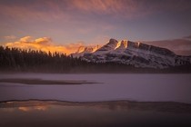 Mist rising off the lake creates an unforgettable sunrise in Banff Canada 