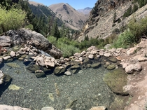 Natural hot spring pools mixed with fresh waterfalls on the side of a mountain with a view Goldbug Trail Elk Bend Idaho OC