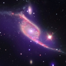 Nested in Pavo the Peacock constellation two galaxies are merging into one while the rapidly growing black hole AGN in the smaller one is using its larger peer as a food source Credit NASA Chandra X-ray Observatory