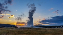 Old Faithful Geyser in Yellowstone National Park at sunset 