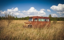 Old Rusted Bus in a Field  by R Alina Photography