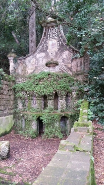 Old sanctuary-style now dry water fountain lost in the forest 