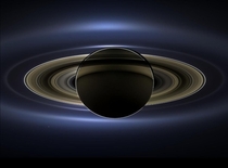 On July   in an internationally celebrated event NASAs Cassini spacecraft slipped into Saturns shadow and turned to the image of the planet seven of its moons  its inner rings - and in the background our home planet Earth