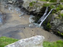 photo from near the top of tintagel castle of the waterfall on the beach bellow in camera tilt-shift toy town effect from my little handbag camera 