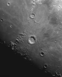 Photographing the Moon through a telescope allows for shadows across mountains and craters to become prominent 