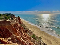 Praia da Falsia Portugal - the distinctive orange red cliffs make for a great contrast against the water 