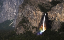 Rainbow colors form at the base of Bridalveil Falls in Yosemite National Park 