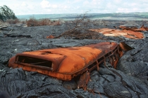 Rusted remains of a school bus eaten by lava in Kalapana Hawaii photographer unknown 
