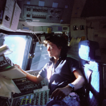 Sally Ride the first American woman in space looks out the window of the Space Shuttle Challenger in  