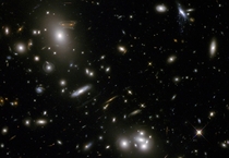 Second image of the Hubble Telescope Advent Calender deep field shows gravitational lensing of massive galactic cluster Abell  magnifying brightening and distorting distant galaxies behind it 