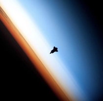 Silhouette of a Space Shuttle at Earths limb