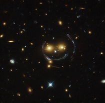 Smiley face in space this is a phenomena known as gravitational lensing Its where gravity is so strong from a distant object that it warps the spacetime around a body in between Earth and the massive body