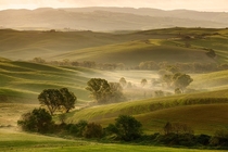 Soft light over the foggy valley of Val dOrcia Tuscany Italy  Photo by Tobias Richter