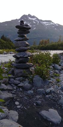 Stack of stones in the foreground of an unnamed mountain found while hiking along a glacier stream near Whittier Alaska 
