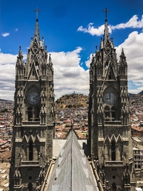 Standing atop the breathtaking Basilica del Voto Nacional in Quito Ecuador The Virgen de El Panecillo watches over the city from the hill beyond 