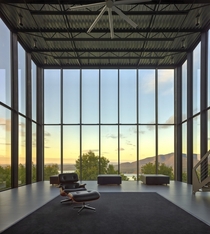 Steel-framed living room of Shokan House with views across treetops to the Ashokan reservoir just below the summit of a Catskill mountain Ulster County New York 