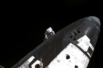 STS- Astronaut Stephen Robinson attached to ISSs Canadarm on the underside of Space Shuttle Discovery OS