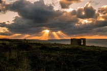 Sun Spears over the remains of a tin mine in Cornwall England