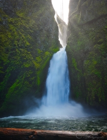 Sunrays piercing through waterfall mist at Wahclella Falls Oregon USA 