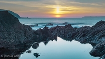 Sunset through a welsh rock pool Pembrokeshire coast national park Wales 