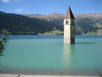 The Bell Tower of the old town of Curon now under water of the dam of the reservoir of Lake Resia Italy 