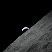 The crescent Earth rises above the Moons horizon in this photograph taken from the Apollo  spacecraft in lunar orbit during its final lunar landing mission in the Apollo program 