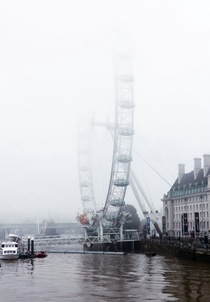 The London Eye disappearing into the mist UK Image - Ron Timehin