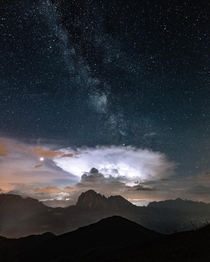 The milky way and a storm cloud erupting over the mountains of Northern Italy 