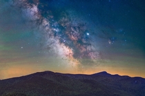 The Milky Way core rising over the high peaks of the Adirondack Mountains during this months new moon captured alongside stripes of green and pink airglow 
