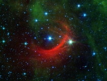The red arc in this infrared image from NASAs Spitzer Space Telescope is a giant shock wave created by a speeding star known as Kappa Cassiopeiae 