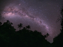 The southern Milky Way viewed over the hilltops lined with palm trees just outside a village in Turkey