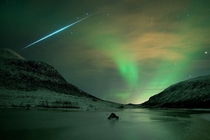 The sudden flash of a fireball meteor from the  Geminid meteor shower streaks across an Aurora Borealis-filled night sky near Troms Norway  by Bjrnar G Hansen