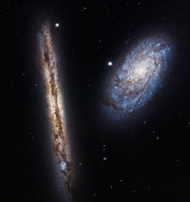 This Hubble image marking the th anniversary of the space telescopes launch features the edge-on spiral galaxy NGC  and the tilted galaxy NGC  Theyre both about  million light-years away both part of the Virgo Cluster in the constellation Coma Berenices