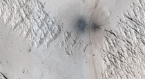 This image shows the land near Mangala Valles on Mars At the bottom of the image there are two black dots which are recent impact craters This image comes from Nasa