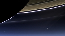 Through the brilliance of Saturns rings Cassini caught a glimpse of a far-away planet and its moon At a distance of just under  million miles Earth shines bright among the many stars in the sky distinguished by its bluish tint