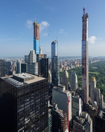 Two helicopters fly near New Yorks pencil-thin skyscrapers