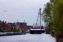Two river container ships navigating the narrow stretch of the channelized river Gouwe through Boskoop The Netherlands 