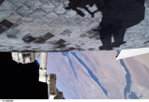 US Astronaut Steve Robinson casts a shadow on Discoverys Thermal Protection Tiles during a spacewalk as part of the STS- mission 