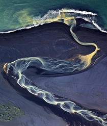 Volcanic river runs to the sea Iceland 