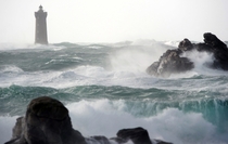 Waves break around the Four lighthouse in Porspoder France Fred Tanneau 