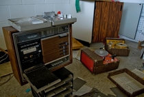 Wonderfully retro woodfaux wood paneled audio equipment at a learning center inside a defunct military gymcommunity center I cant identify what the strange aluminum device on top of the tape recorder is Can anyone else OC x